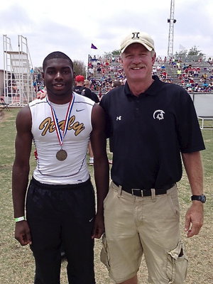 Image: Senior Gladiator TaMarcus Sheppard displays his silver medal in the high jump with Italy’s AD/HFC Charles Tindol at Tindol’s old stomping grounds in Abilene.