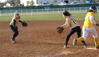 Image: She’s out! — Second Baseman Abby Griffith flips it to 1st baseman Drew Windham for the out.