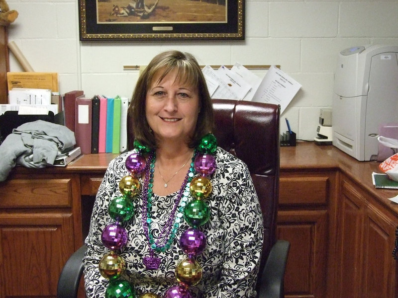 Image: Gwen is glistening — Gwen Harris has kept her beads from previous celebrations of Mardi Gras held at IHS.  Her daughter offered her own beads for the occasion.