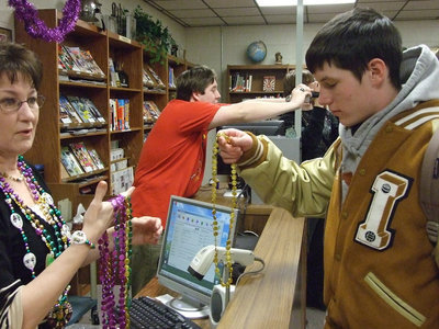 Image: Can I have gold? — Librarian Sharan Farmer offers different colors of beads to the students who attended Mardi Gras.
