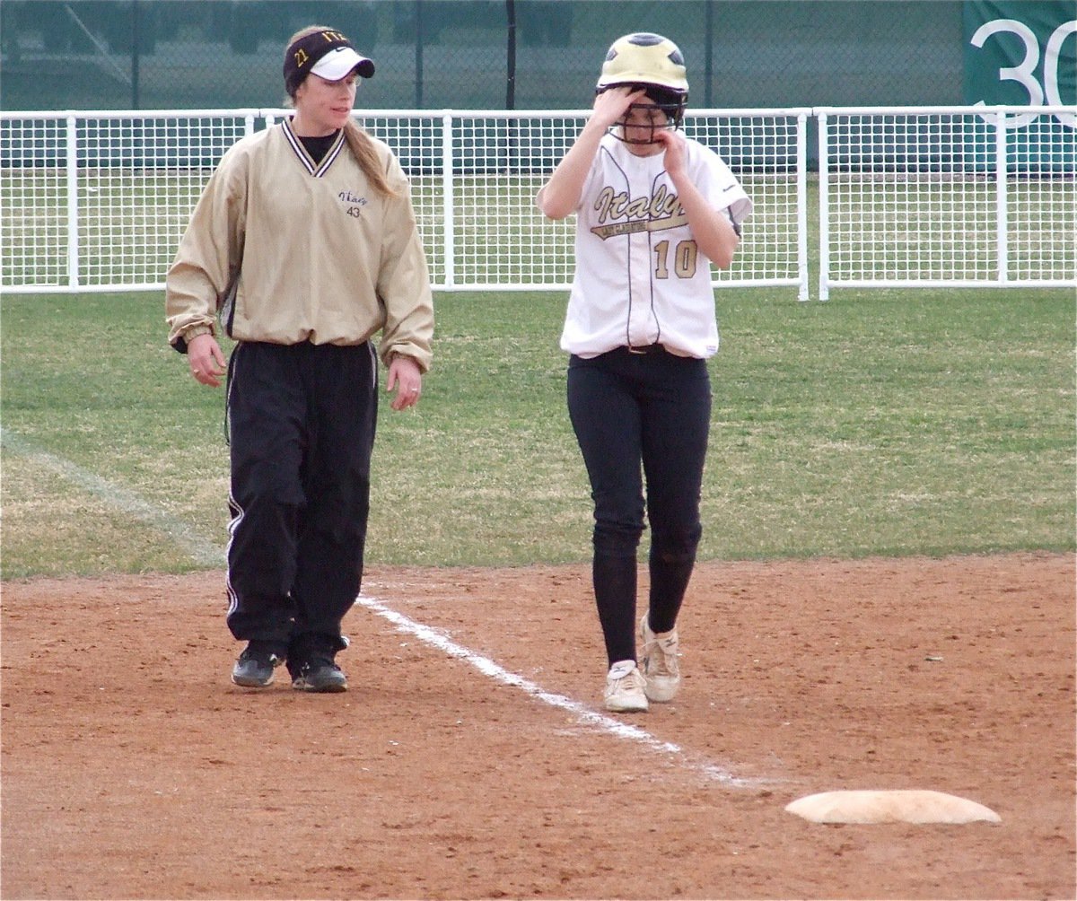 Image: Toughing it out — Courtney Westbrook makes it to 3rd base but aggravates a leg injury and walks it off with coach Jennifer Reeves.