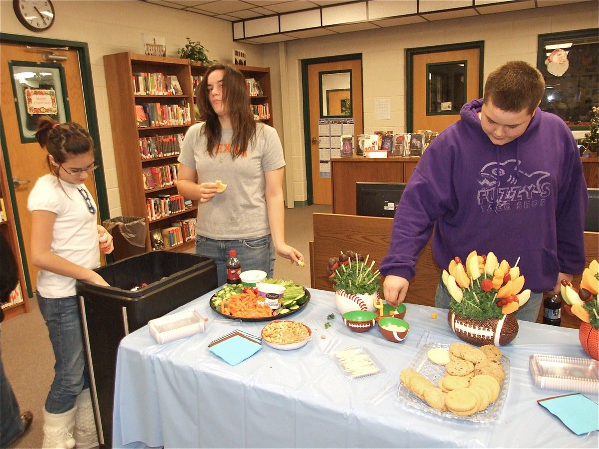 Image: Make room for Kix — Kaci, Kaytlyn and Kelton enjoy the snacks offered during the baby shower. It looks as though Kix will be learning the spirit of competition early.