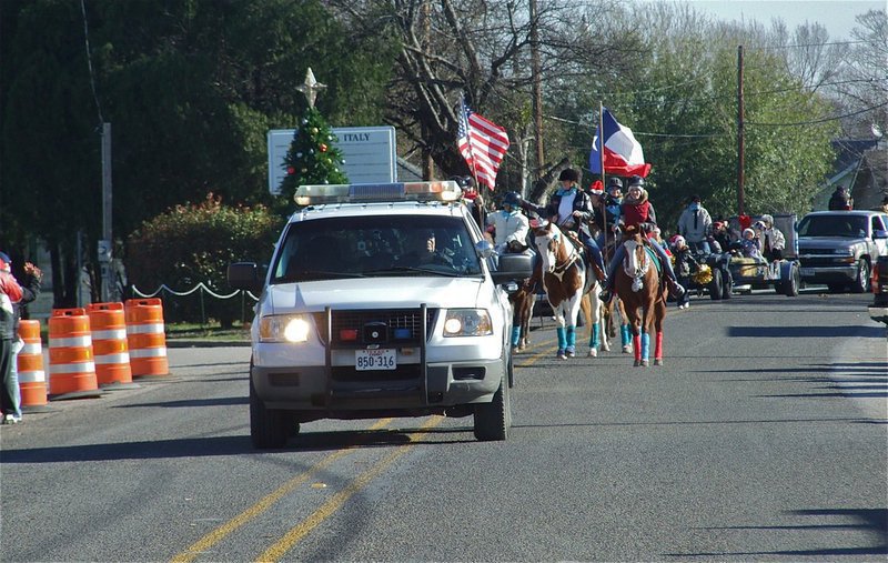 Image: Here they come! — Italy Police Chief C.V. Johns escorts the Christmas parade into downtown Italy. There were horses and a goat, fire engines and floats and Mr. and Mrs. Claus who brought Christmas cheer to all.