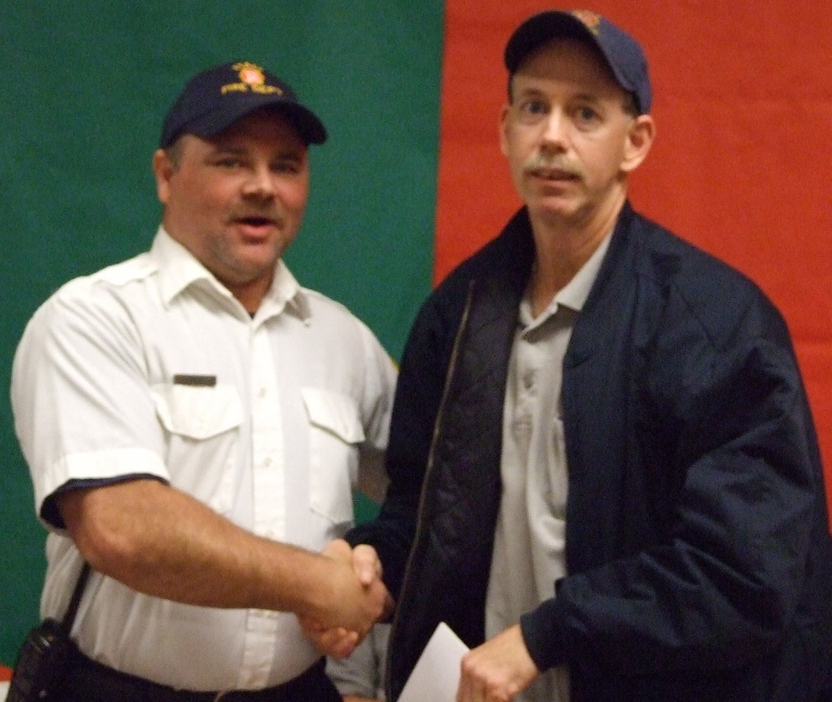 Image: Jackie and an “old dawg” — Tommy Sutherland receives a big handshake from Captain Jackie Cate for achieving Valedictorian in his class.  Sutherland thanked everyone for allowing the opportunity to learn and explained how his classmates mean so much.  “I have learned from everyone in my class, from each fireman.  You all have taught me this year.  I guess you CAN teach an old dog new tricks,” Tommy adds with a smile.