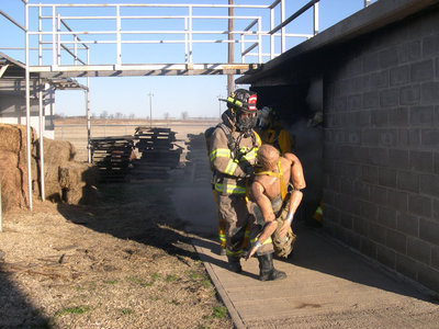 Image: That dummy weighs a lot — One of the requirements of the firemen is to retrieve the 160lb dummy from the smoke filled house.