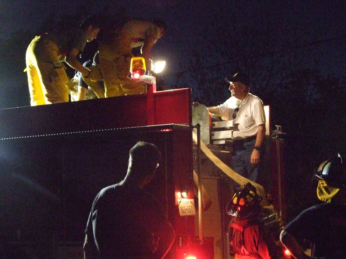 Image: Chief watches his students — Chief Chambers instructs the new firemen about the hoses.