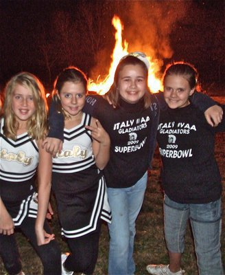 Image: A-Team Cheerleaders — Hannah Washington, Brooke DeBorde, Amber Hooker and Lillie Perry hug after cheering in front of the IYAA bonfire.