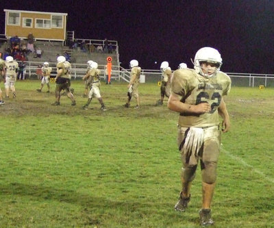 Image: Kevin is covered — Offensive center Kevin Roldan heads for the sideline caked with mud.