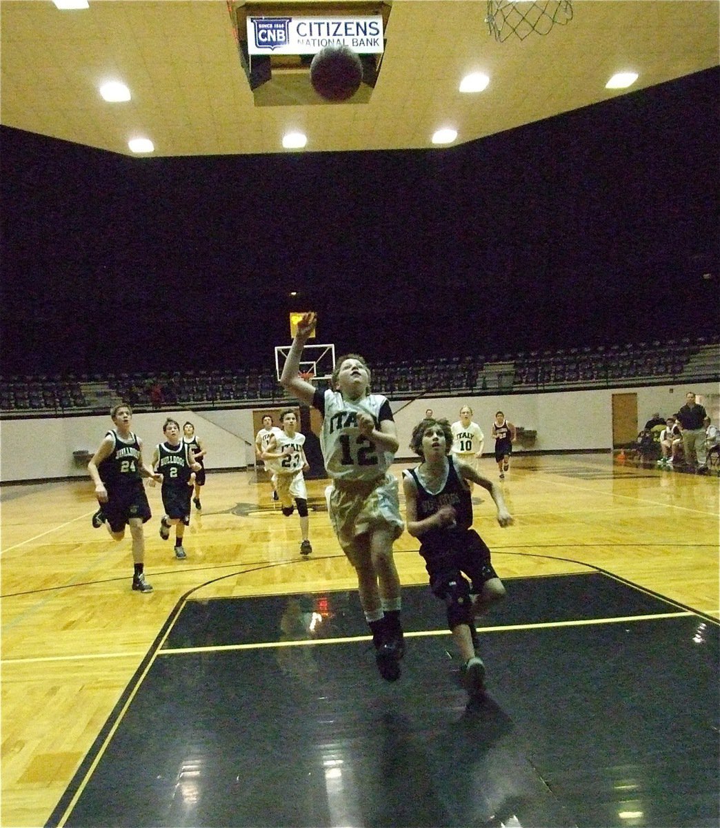 Image: Making a play — John Escamilla(12) races down court and lofts up a shot.