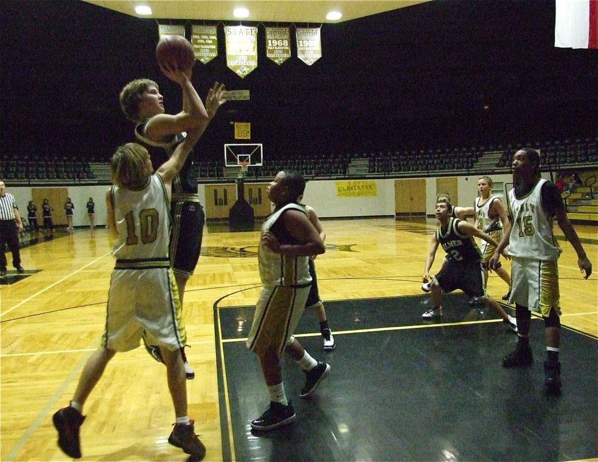 Image: Kyle defends — Kyle Machovick(10), Darol Mayberry and Treyvon Robertson(15) try to clog the middle against Palmer.