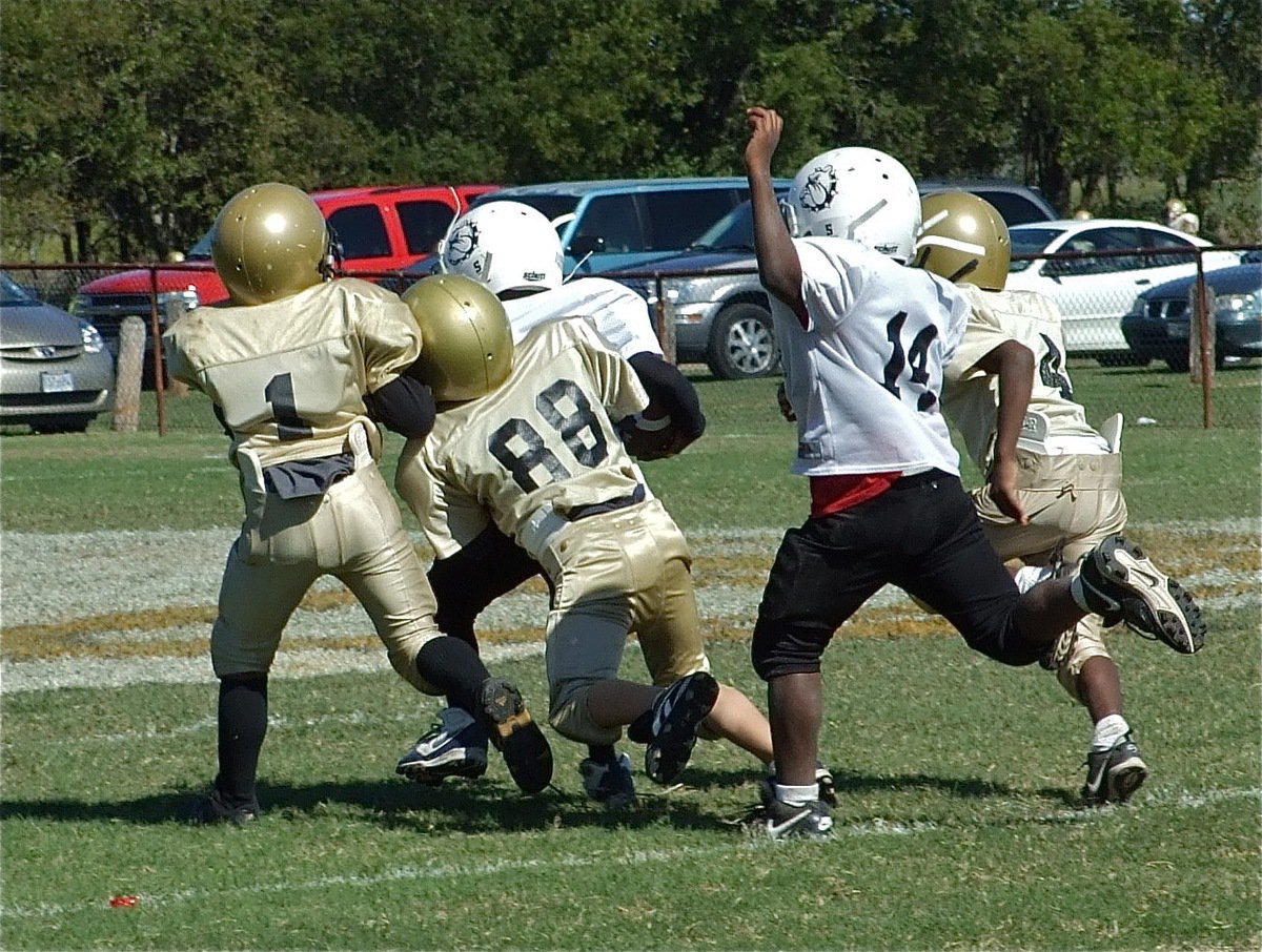 Image: Dog catchers — Kendrick Norwood(1), Corbin Schrotke(88) and Jaylon Davis(4) preserve the B-Team’s 27-0 shutout by pulling down a Bulldog befor he scored.