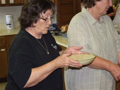 Image: Easy as gravy — A concentrating Karen Mathiowetz delivers the gravy to lunch line, without spilling a drop.
