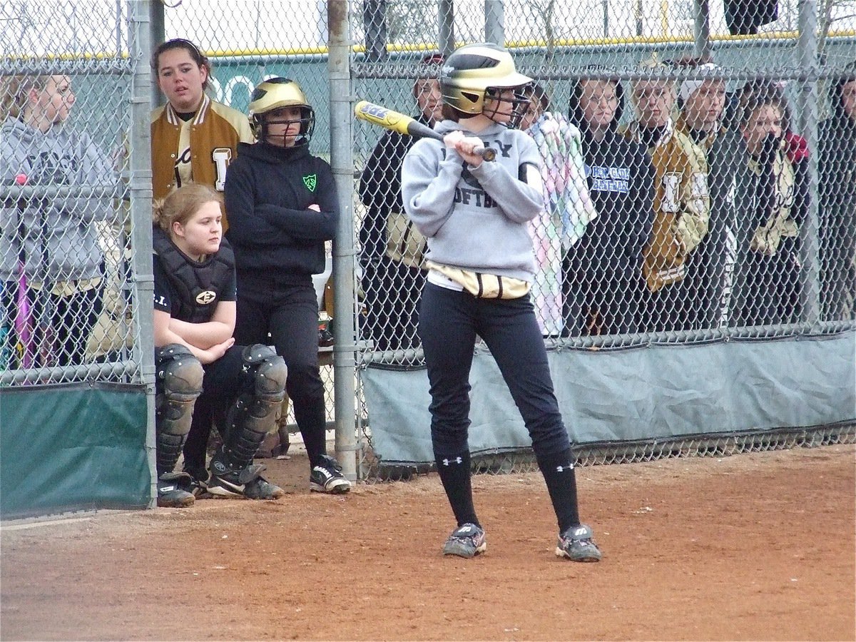 Image: Drew Windham and the Lady Gladiators were ready for the Lions — Drew Windham(14) checks out the speed of the Blooming Grove pitcher while her Lady Gladiator teammates are ready to bust out of the cage against the Lady Lions.