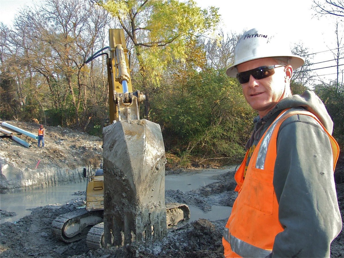 Image: TTG superintendent Jeff Ayers has his hands and bucket full — TTG Utilities, LP superintendent Jeff Ayers claims the Couch Street Bridge demolition has been the most difficult demolition project of his career. Digging 13 feet down into Italy’s famous whiterock has been no easy task for the Gatesville based crew.