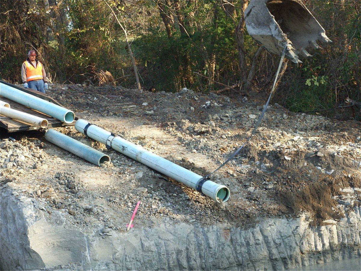 Image: Dragging the pipes — The crews began setting the underground pipes today.