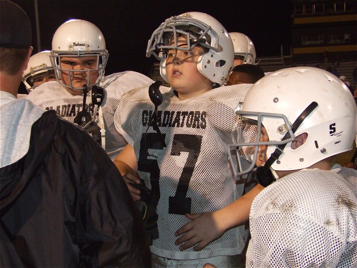 Image: Learning the ropes — Hank Seabolt, Tristen Smithwick(57) and Mr. J.T., John Escamilla, had big plays for the IJH Gladiators during the fight against Hubbard.