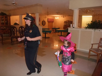 Image: Cake Walk — Teresa Dalenilie (Director of Nurses) is having fun playing the cake walk game with the cutest little witch in pink.