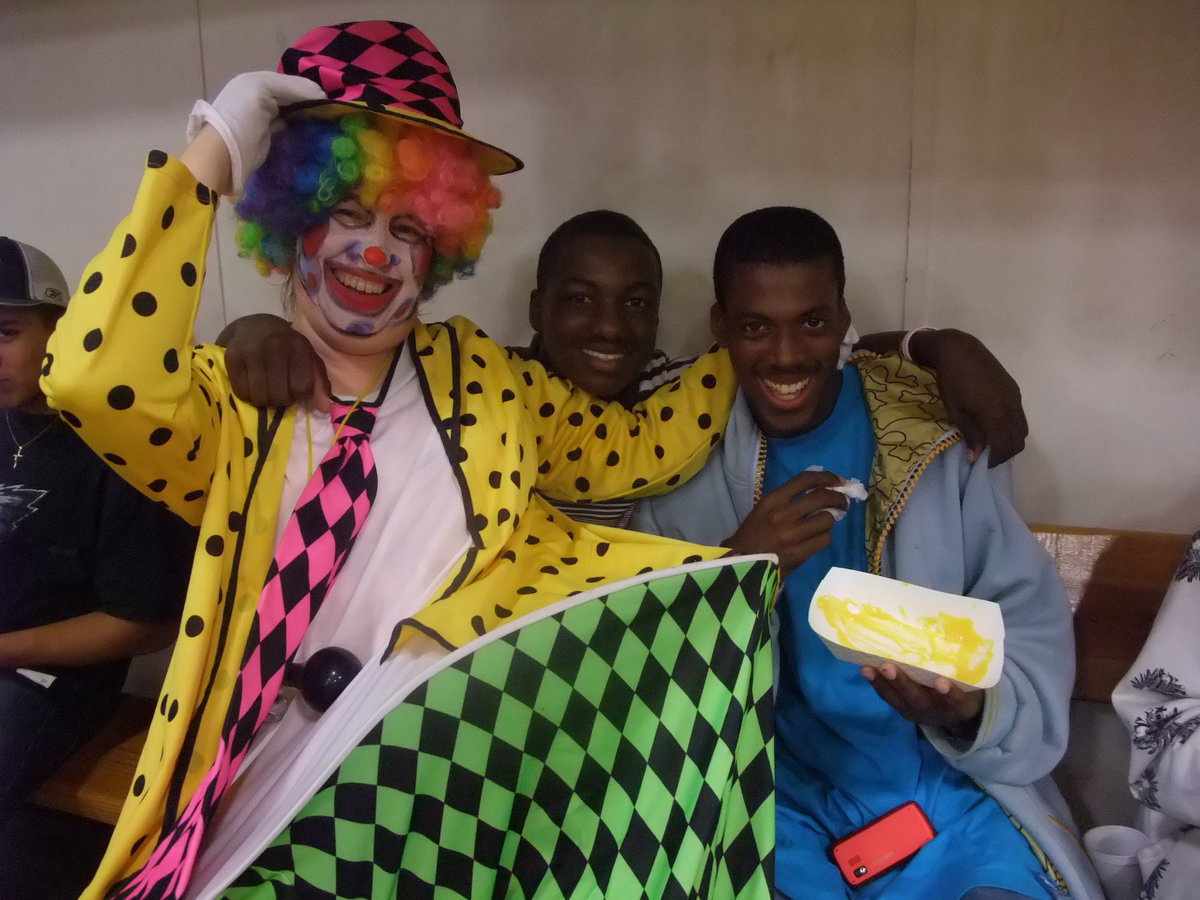 Image: Sally, A Team Player — Sally the Clown and Corrin Frasier, cornerback for the JV football team and John Isaac, receiver for Italy’s varsity football team.