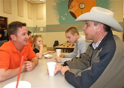 Image: Supporting the PTO — A good meal for a good cause as Jody Mathers and his daughter Addy sit and chat with Curtis Riddle and his son Clay.