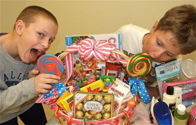 Image: Licking the competition — Instead of bidding on the giant candy basket, these two decided that licking the lollipops would detour interest from outside bidders.
