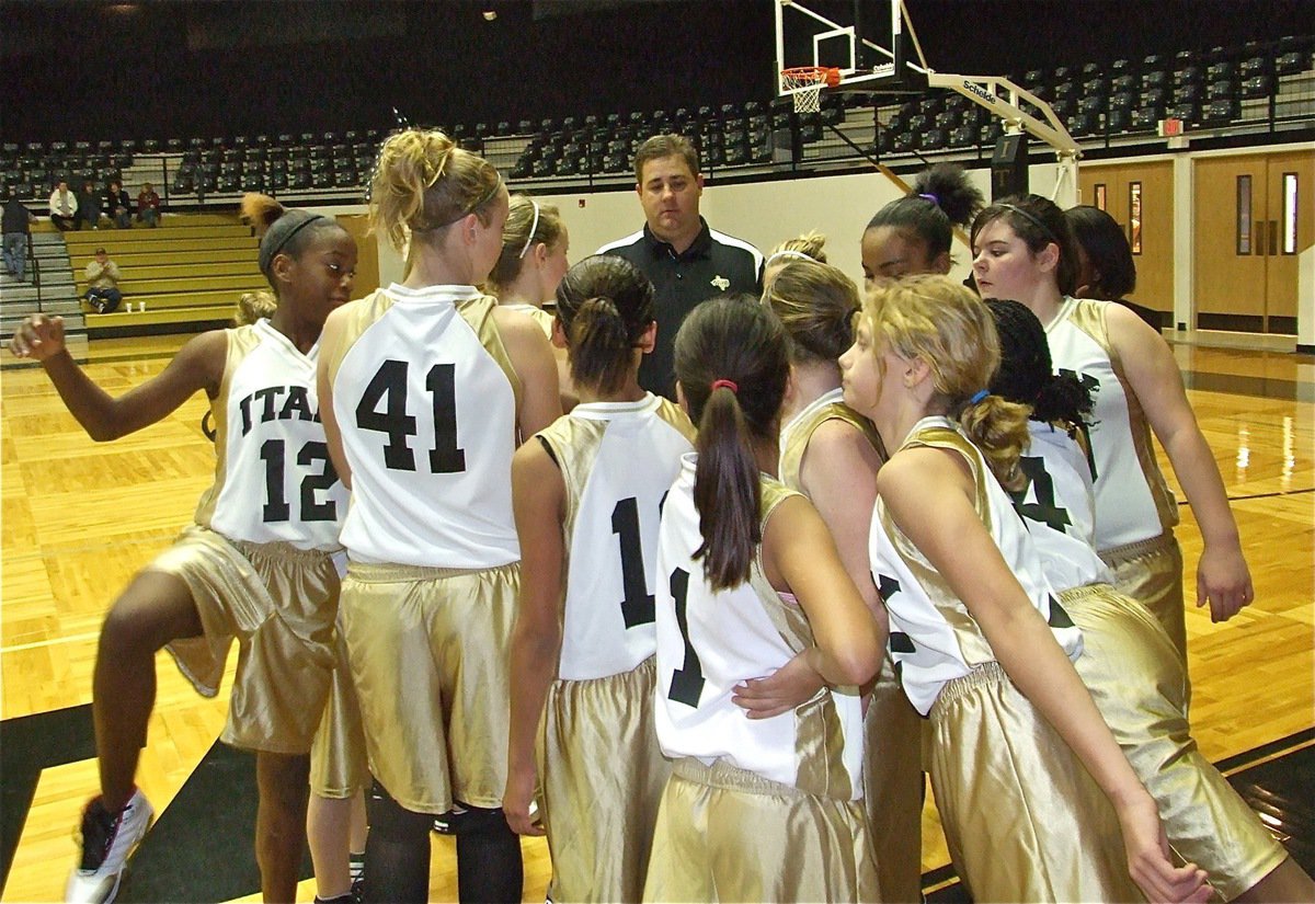 Image: Everybody lean in — Coach Matt Coker and the 7th grade girls fall in for a break before their game against Dallas Life.