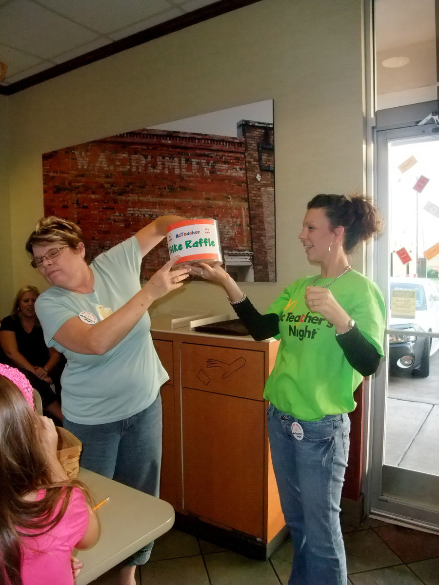 Image: Who’s the Lucky Winner? — Paula Mandrell is pulling out the winning raffle ticket for the shiny red bike.