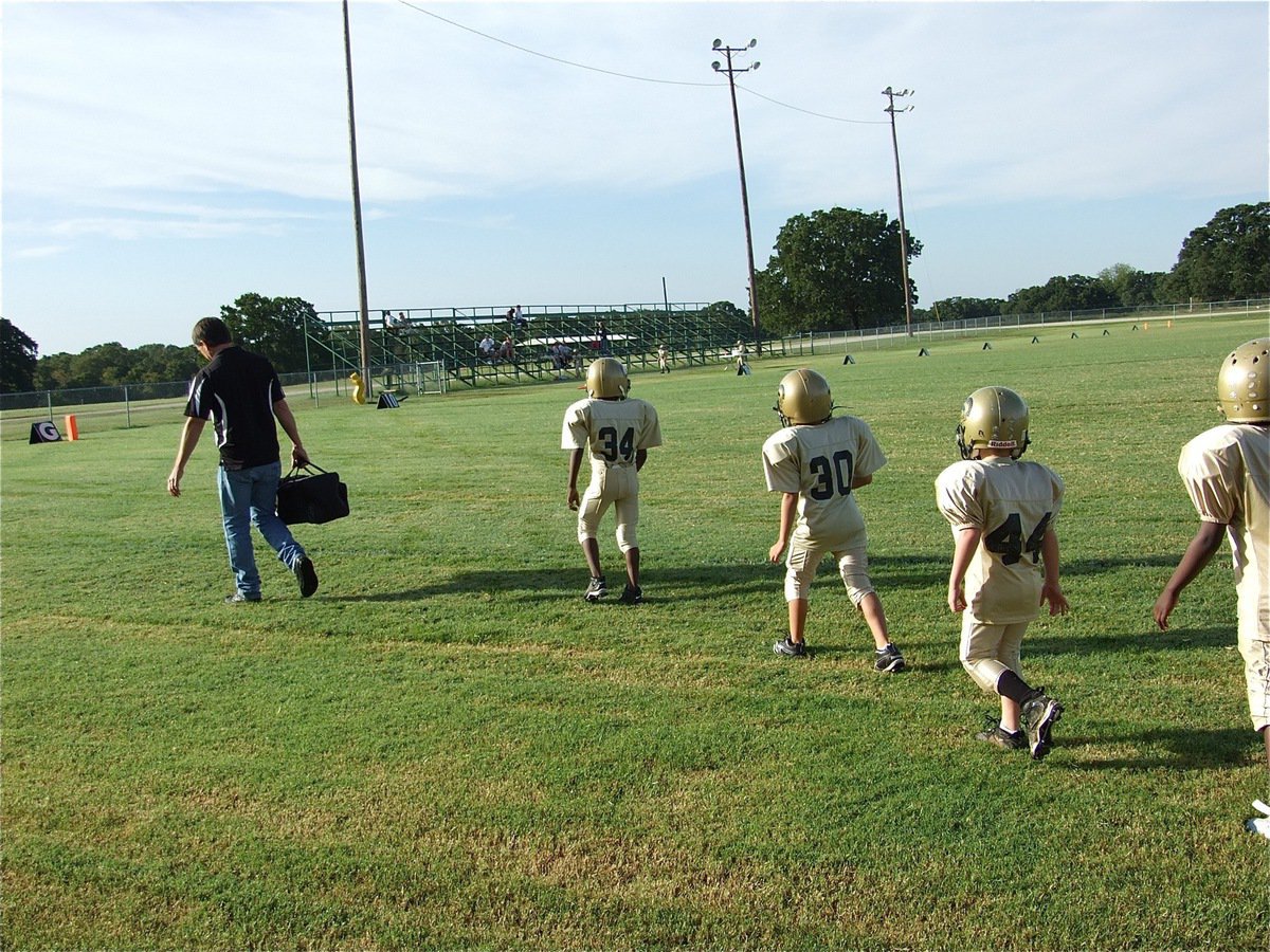 Image: Gladiator ducklings — Coach Gary Wood leads his young Gladiator ducklings into Wildcat stadium. Don’t let their size fool you, the C-Team knocked the quack out of Scurry-Rosser for a 25-0 win.