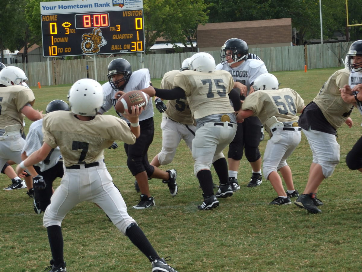 Image: John Escamilla to pass — John Escamilla (7) heaves a completion to Colton Petry for 9-yards during the scrimmage against the Palmer Bulldogs Thursday. Lightning and heavy rains prevented the 8th Grade and JV teams from seeing any action.