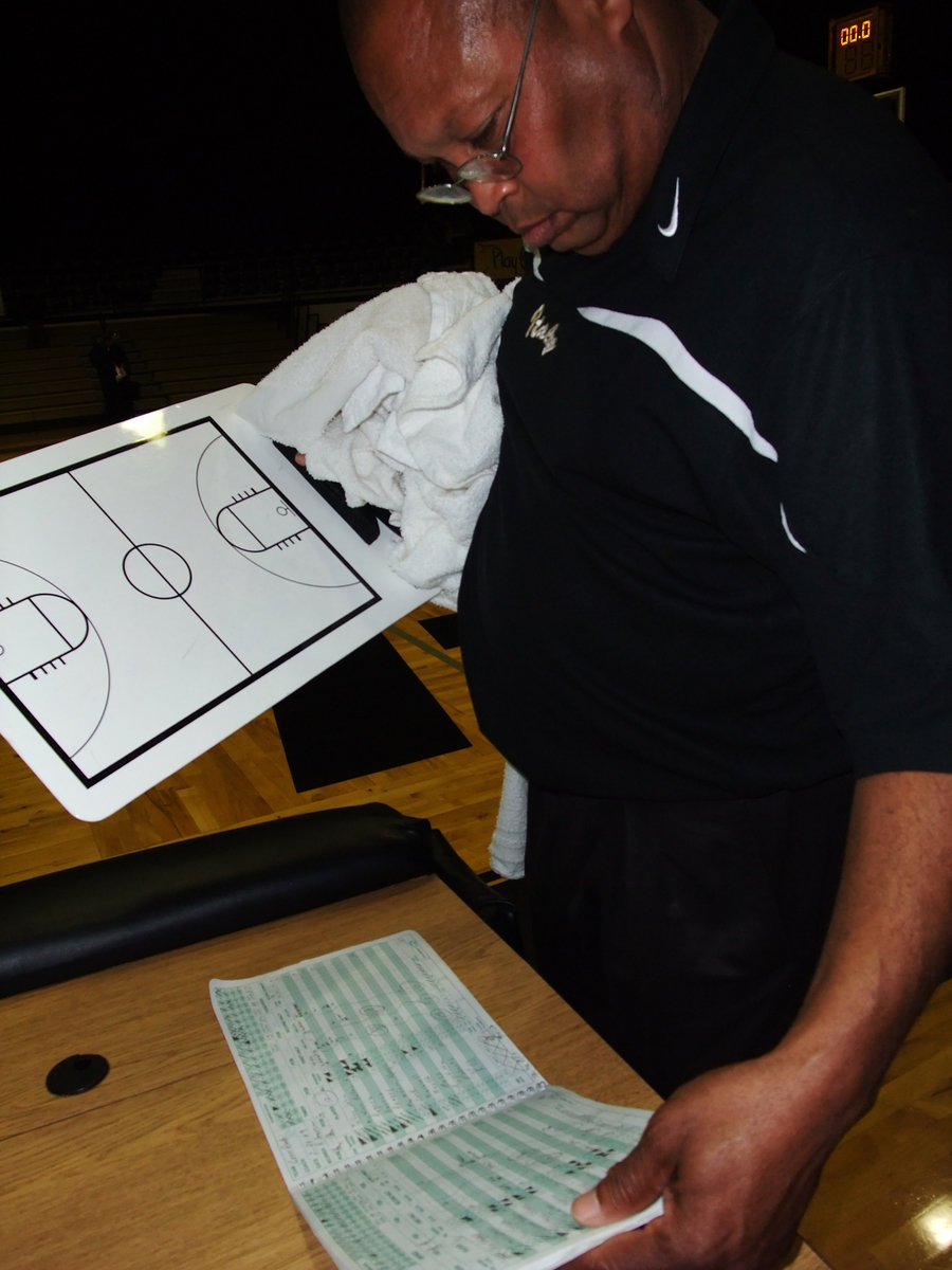 Image: Coach Larry Mayberry — After the game, Coach Larry Mayberry checks over the books before heading to the locker room.