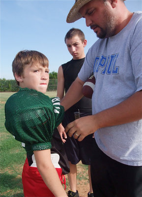 Image: Let’s play PHATball — Aaron Itson gets his youngest son, “Phat,” ready for action while big brother, Bubba, looks on.