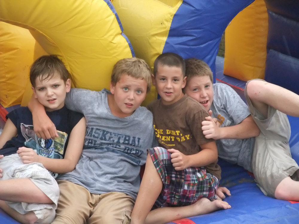 Image: From sliding into home to slipping on the water slide — James, Bailey, Gary and J.T. take a break on the water slide during the end of the year IYAA Baseball/Softball Party.