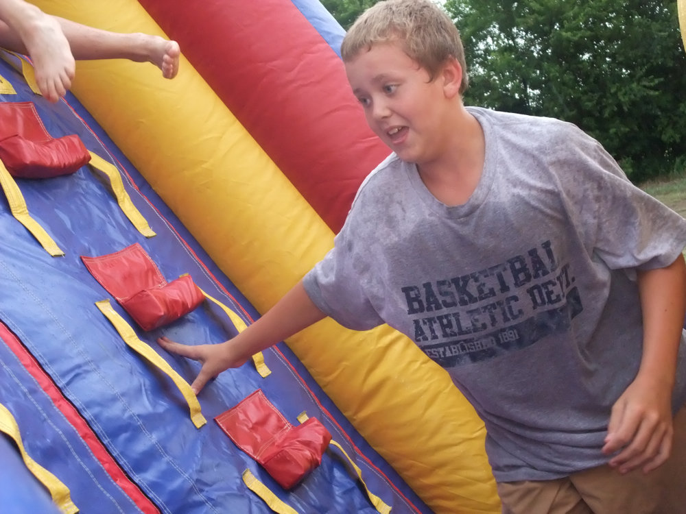 Image: A competitive spirit — 1st Baseman Bailey Walton appears to be in 2nd place during the water slide race.