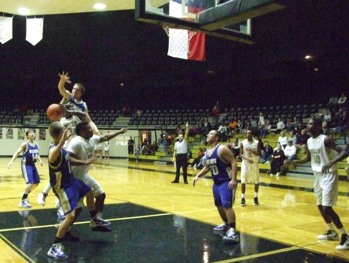 Image: Rettig defends — De’Andre Rettig helps teammate make the basket.