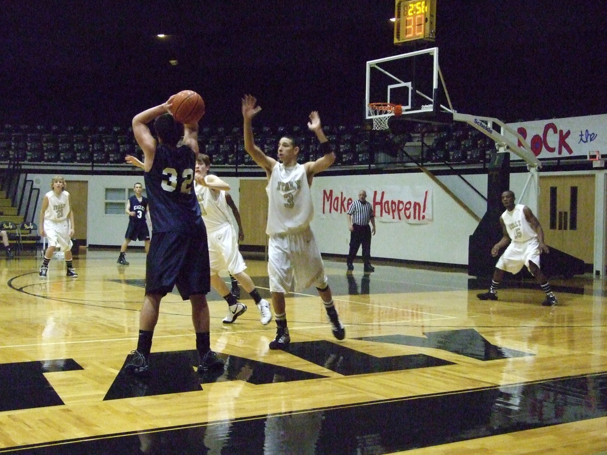 Image: Oscar and Crownover — Oscar Gonzalez #3 and Dan Crownover #20 get help from Donald Walton #21 and Desmond Anderson #15 in defending against the Eagles.