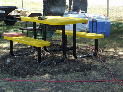 Image: Picnic Bench  — It is a bright yellow new and shiny picnic table for picnics at the park.