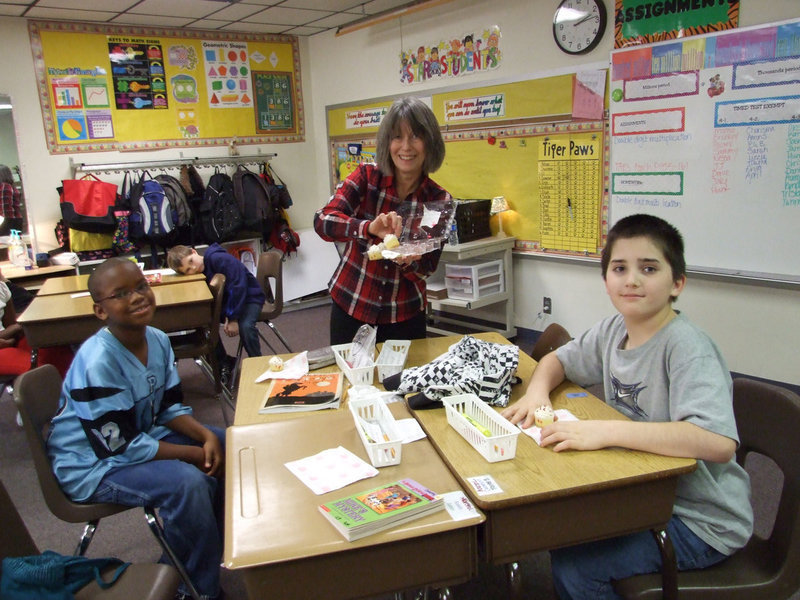 Image: Carolyn Maevers Helps Out — Carolyn Maevers ( principle) helps out in this celebration by passing out cupcakes.