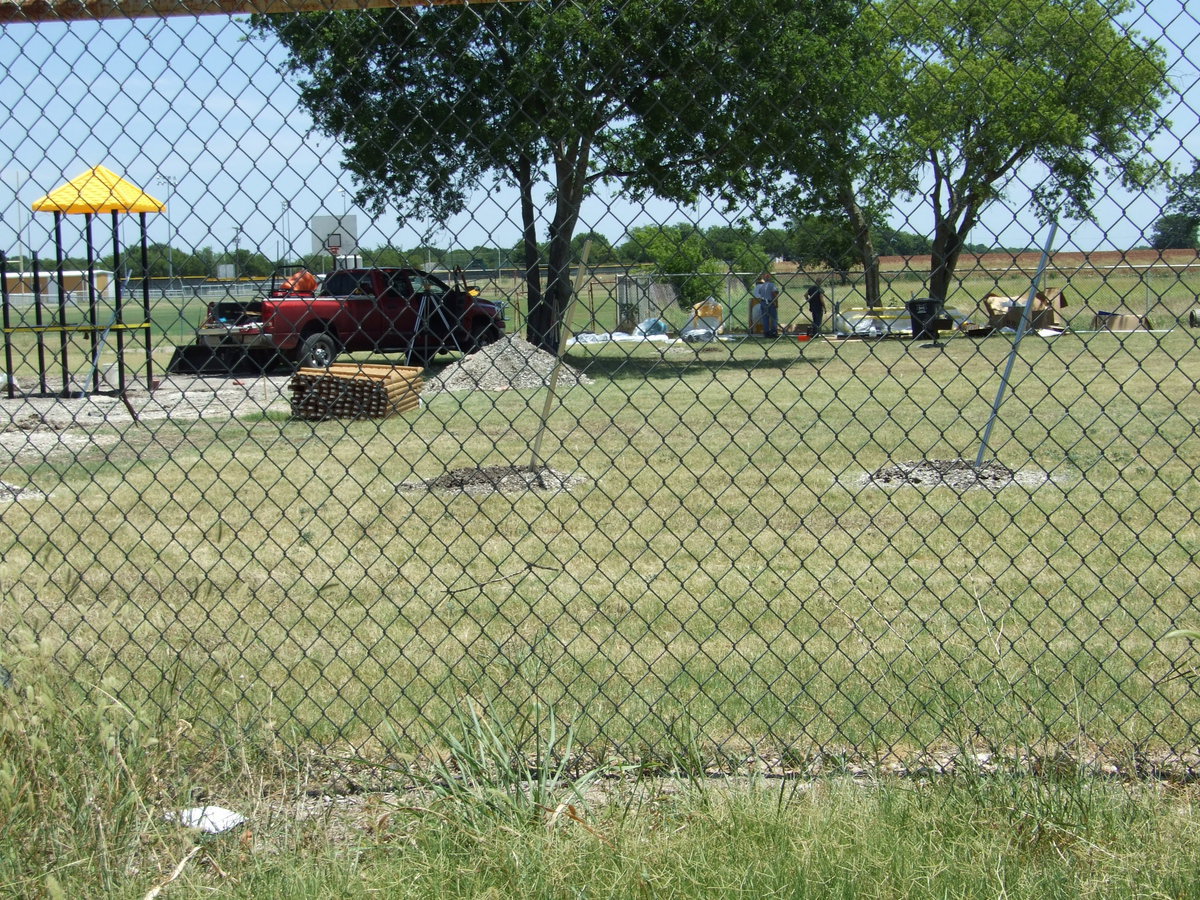 Image: Canopy — Men working getting poles cemented in and the canopy installed.