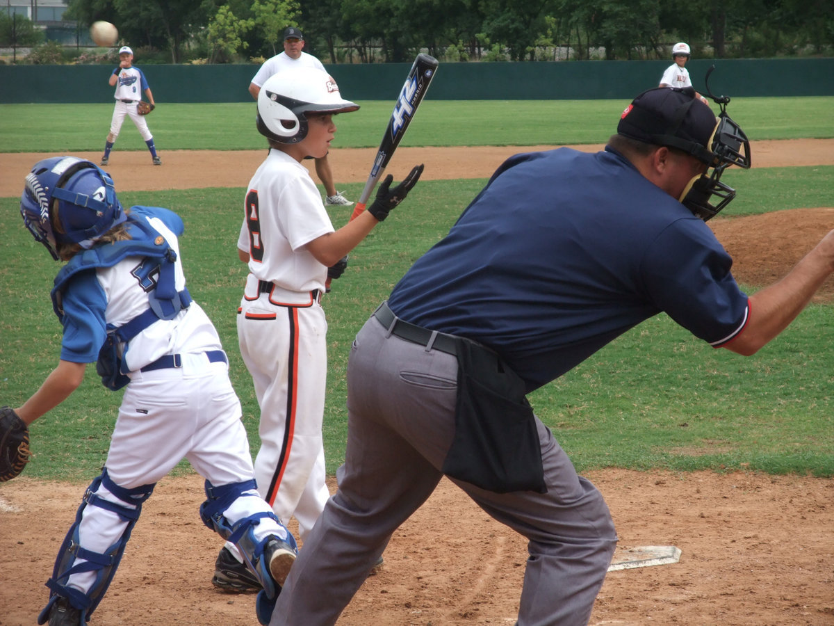 Image: The trifecta — Umpire calls batter out, batter can’t believe the call and the catcher tries to catch the runner at 3rd base napping…we love this game!