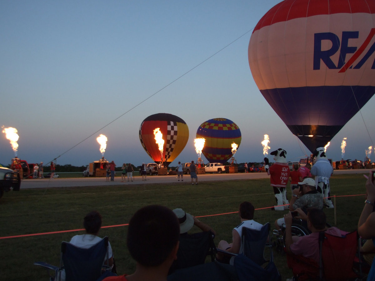 Image: Hot Air Balloons — The pilots of the hot air balloons are demonstrating an “all burn”. An “all burn” is when the pilots send up long flames of fire.