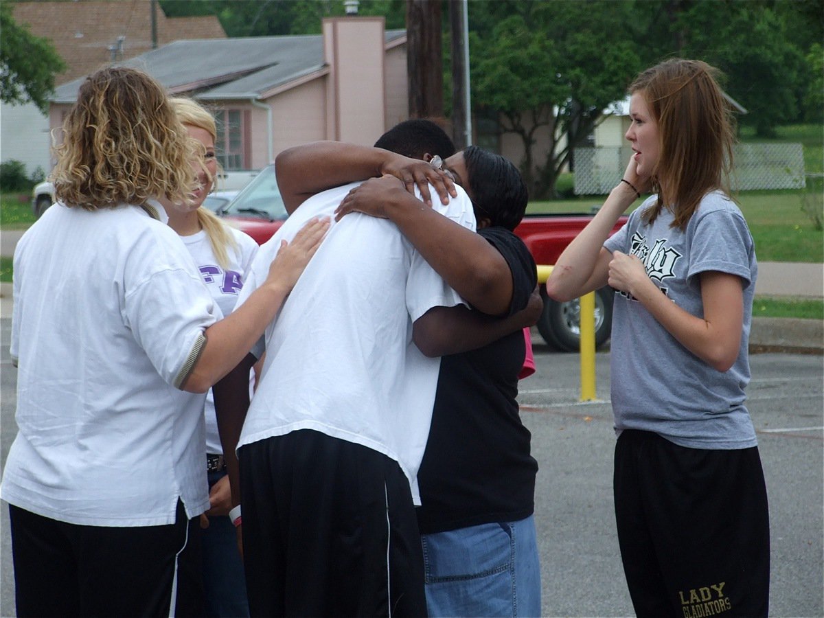 Image: More hugs for John — Brenda Davis hugs John for a second time as coach Stacy McDonald and IHS students Megan Richards and Kaitlyn Rossa await their turn.