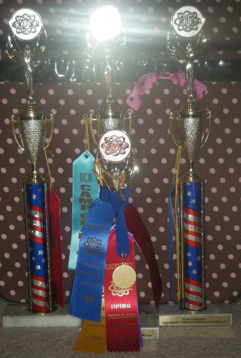 Image: This year our cheering and mascoting, looks promising. — Back: Cheerleading trophies; Front: Mascoting trophy