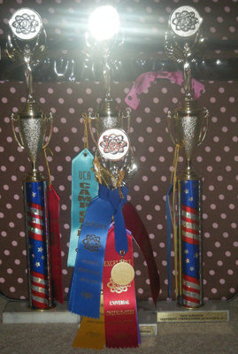 Image: This year our cheering and mascoting, looks promising. — Back: Cheerleading trophies; Front: Mascoting trophy