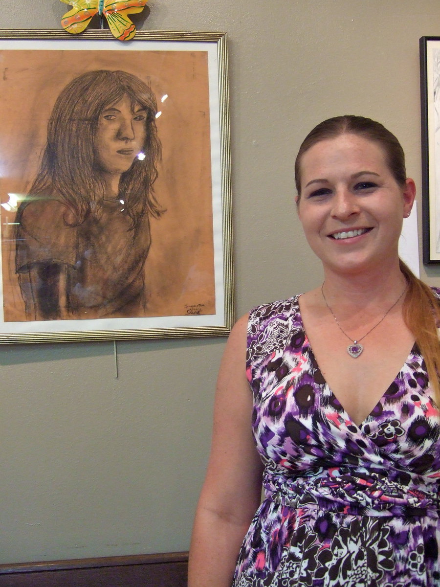 Image: Shelly and Rachel Nance — Rachel Nance is standing next to a self portrait of Shelly.