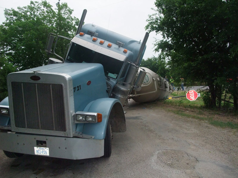 Image: STOP! — Even an ironic stop sign couldn’t keep this 50,000 lb. load of a powdered cement mix from sliding in the ditch.