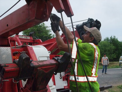 Image: Raising the crane — Keith Helms prepares his tow truck for the raising of the trailer.