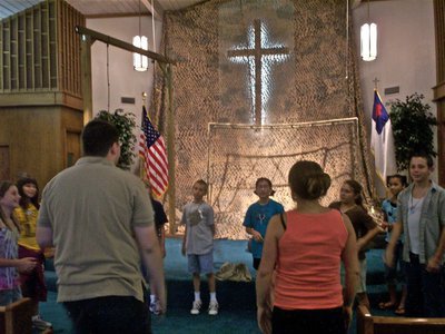 Image: Under the cross — Brian Arnold helps the Prayer Platoon praise the Lord through song.