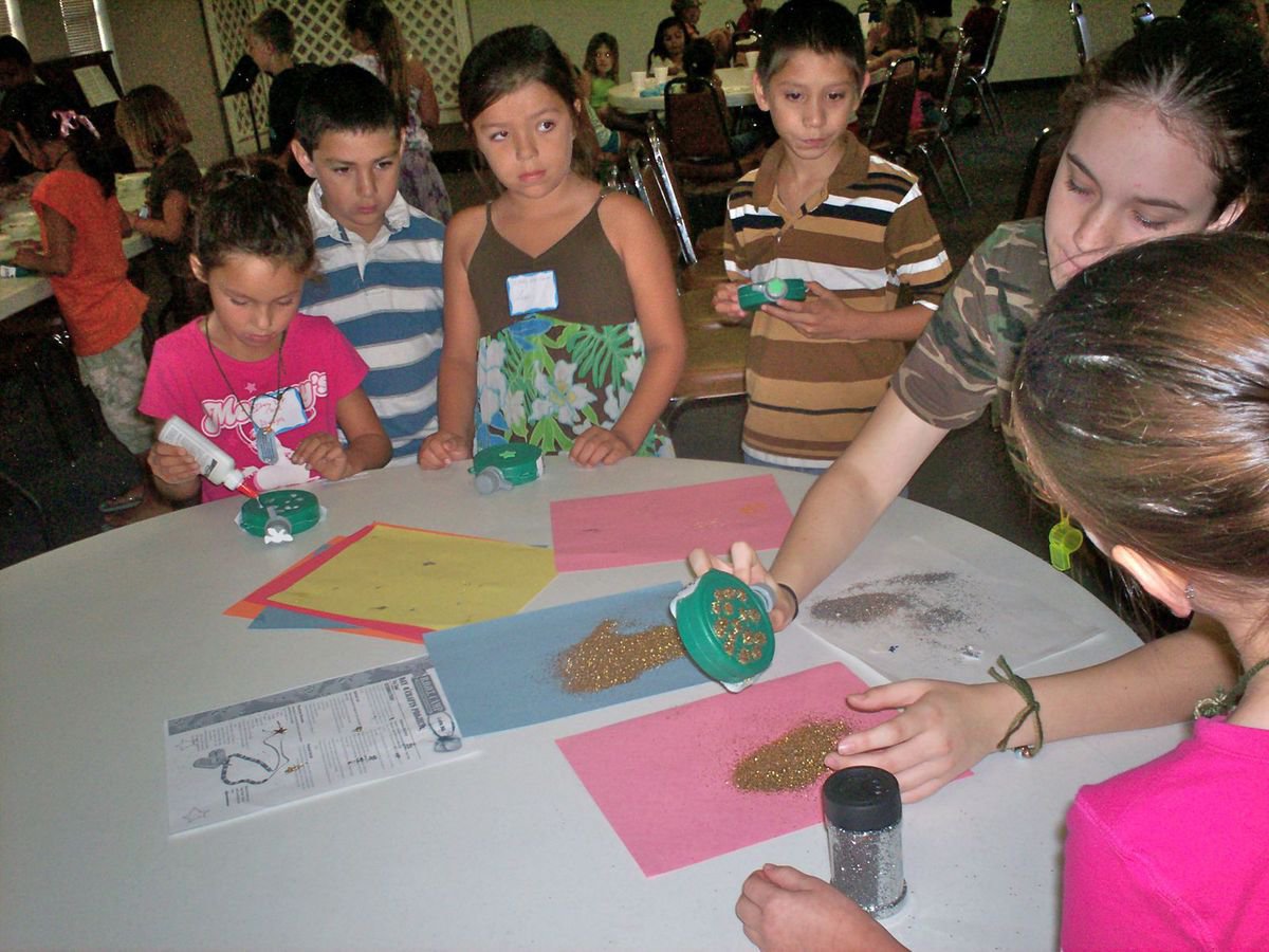 Image: Melissa Smithey — IHS student Melissa Smithey has this young group of Bible Soldiers at full attention as she helps them with glittering their canteens.