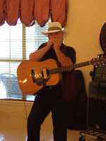 Image: Clyde Farrell playing harmonica — Clyde not only plays his guitar, but plays the harmonica too.
