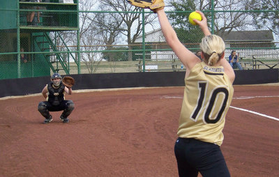 Image: Courtney Warms Up — Courtney Westbrook fires up the cannon with assistance from her catcher, Julia McDaniel.