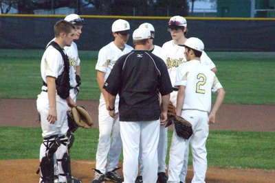 Image: We need to talk — Checking the pitcher, Coach Josh Ward lets the infield know what’s on his mind.
